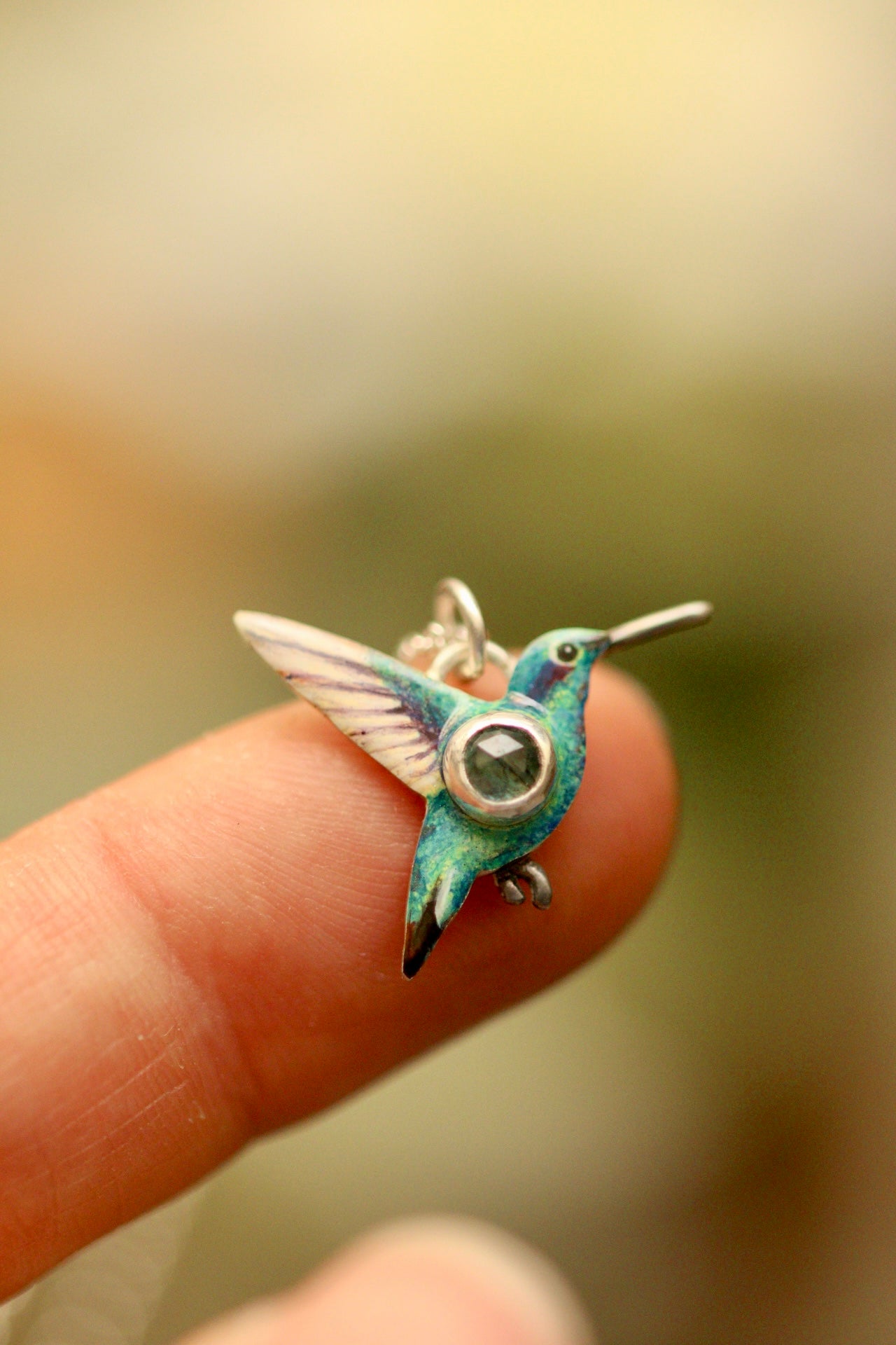 hummingbird pendant with green sapphire